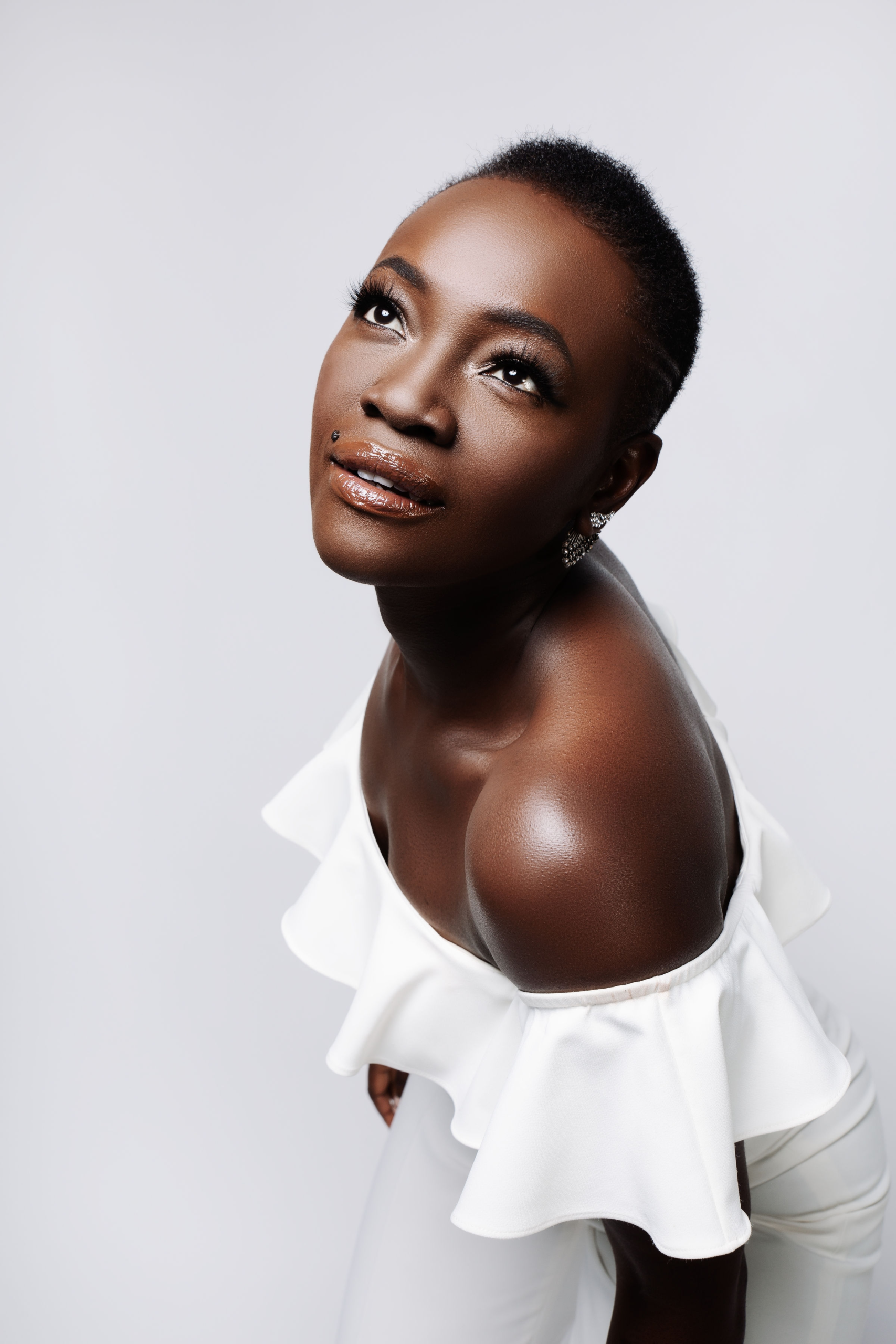 Constance Ejuma in a white off-shoulder jumpsuit.